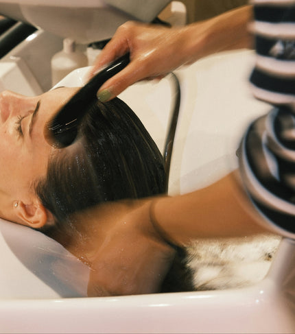 Hair being rinsed at a salon wash basin